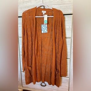Cardigan in a lovely burnt orange color. Never worn.